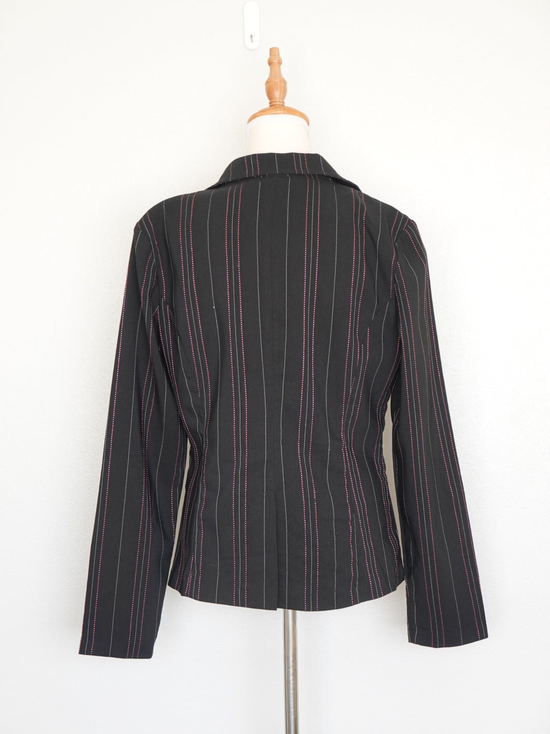 Detalle de botones y rayas grises y rosas en blazer negro Chesley