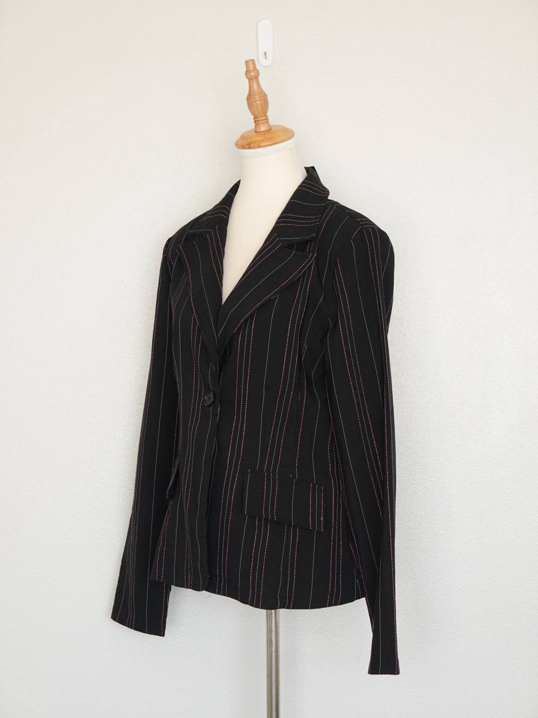 Detalle de botones y rayas grises y rosas en blazer negro Chesley