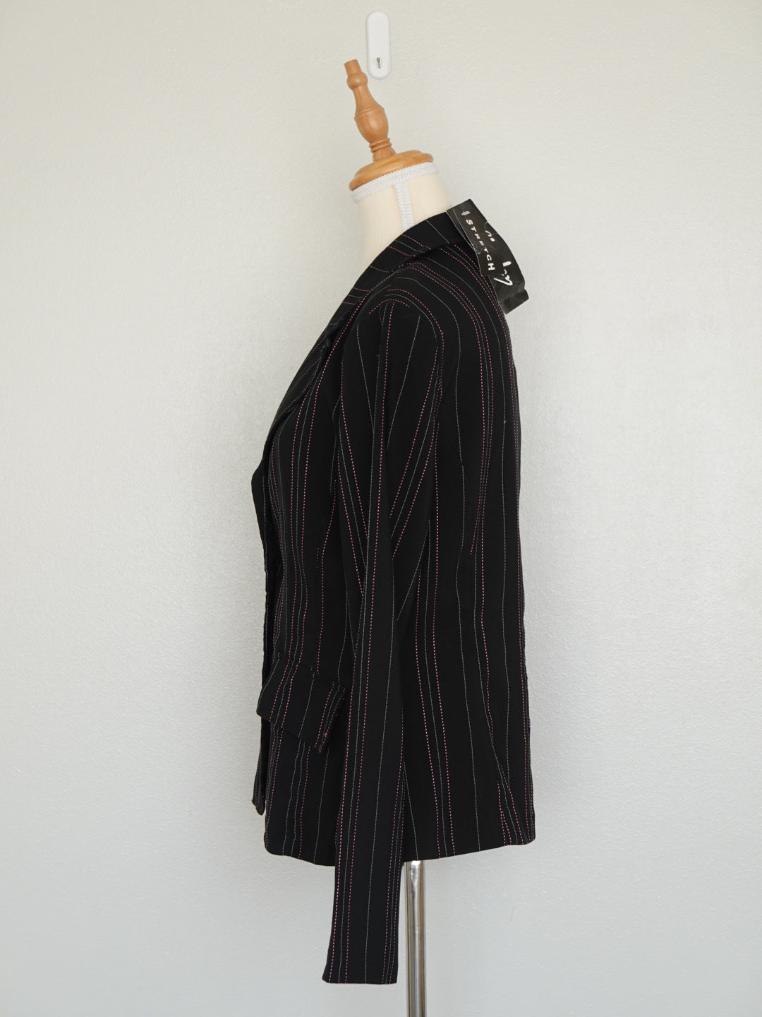 Detalle de botones y rayas grises y rosas en blazer negro Chesley