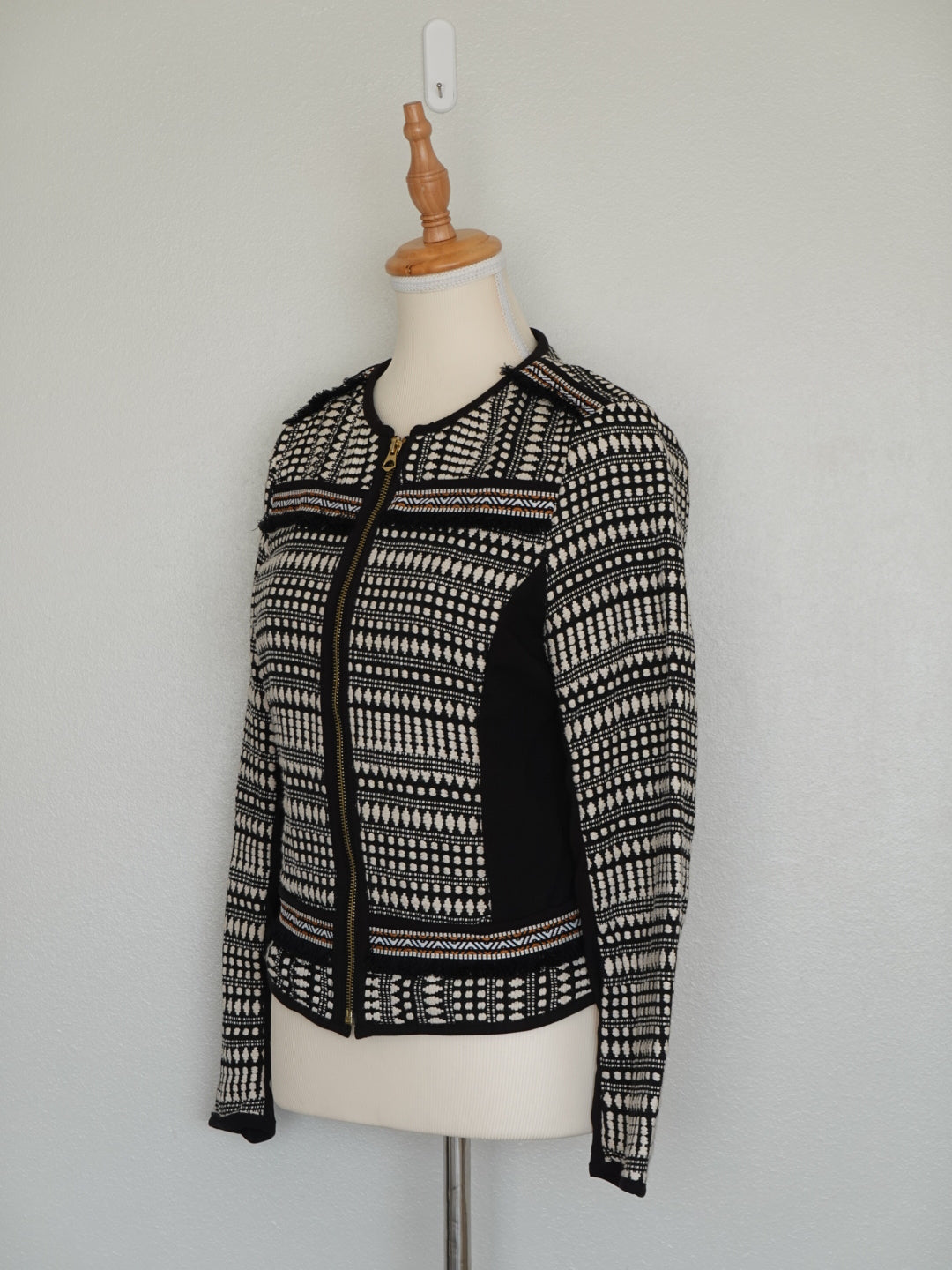 Detalle tejido étnico en blanco y negro con cierre metálico frontal chaqueta Jack