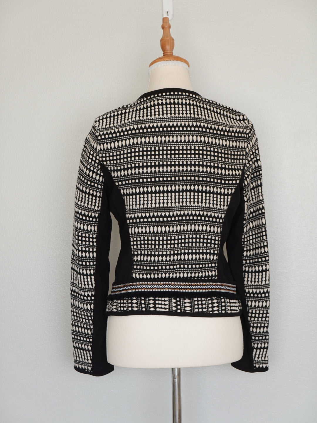 Detalle tejido étnico en blanco y negro con cierre metálico detrás chaqueta Jack